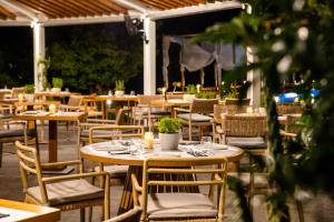 an outdoor restaurant with tables and chairs and candles at Skiathos Avaton Garden, Philian Hotels and Resorts in Skiathos