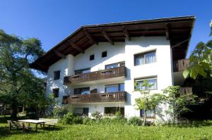 a white building with balconies and a picnic table at Sonnenheimhof in Malles Venosta
