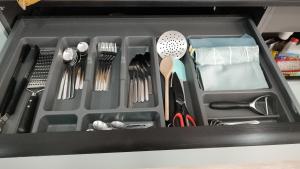 a black tray with utensils in a drawer at Apartamentos las flores in Murcia +6 photos