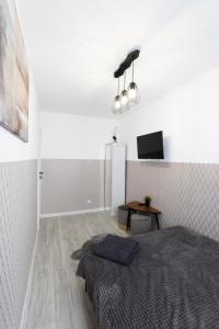 biały pokój z łóżkiem i stołem w obiekcie ClickTheFlat Warsaw Breweries Apart Rooms w Warszawie