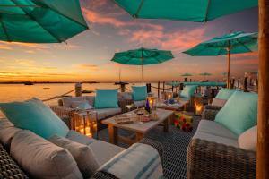 a patio with couches and tables and umbrellas at Bungalows Key Largo - All Inclusive in Key Largo