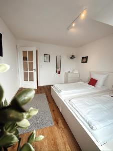 a bedroom with a large white bed and a plant at Design Wohnung im Zentrum von Koblenz in Koblenz