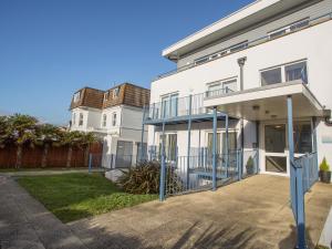 a white house with a porch and a driveway at 1 Blue Waters in Bournemouth