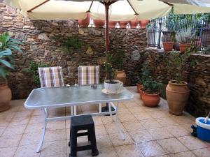 a table with two chairs and an umbrella at CALM SUITE in Sitia