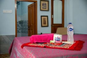 a pink table with a bottle of water and a towel at Little prince guest house & homestay in Bikaner