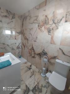 ein Badezimmer mit einem weißen WC und einem Waschbecken in der Unterkunft La casa de las tejas verdes in San Juan de los Terreros