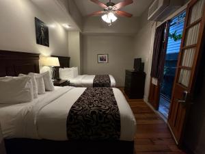 Cette chambre comprend deux lits et un ventilateur de plafond. dans l'établissement Inn on St. Ann, a French Quarter Guest Houses Property, à La Nouvelle-Orléans