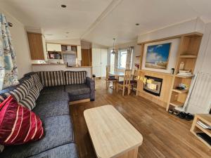 uma sala de estar com um sofá e uma mesa em Caravan 4 - Cambrian Coast Caravan Park em Borth