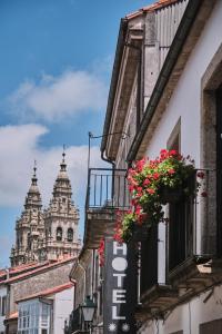 uma rua com flores num edifício com duas torres em Hotel Entrecercas em Santiago de Compostela