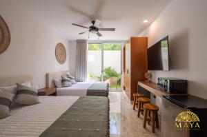 Una televisión o centro de entretenimiento en NHOA 112A Lux 2BR Condo Plunge Pool in Aldea Zama