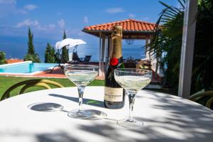 uma garrafa de vinho e dois copos numa mesa em VILLA LOVRAN - 150m to the beach - infinity pool - incredible sea view - Fitnessraum em Lovran