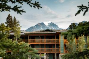 a large building with a mountain in the background at Lake Louise Inn in Lake Louise