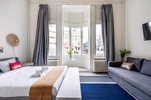 a living room with a bed and a couch at Smartflats - the City Antwerp in Antwerp