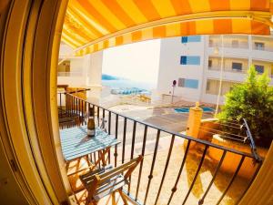balcón con 2 sillas y vistas a un edificio en Apartamento Cristian Playa, en Castell de Ferro