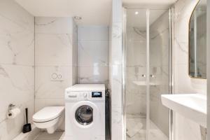 a white bathroom with a toilet and a washing machine at Smartflats - the City Antwerp in Antwerp