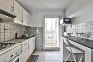 a white kitchen with a counter and a window at Appart Lumineux I Prox Vélodrome in Marseille