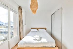 um quarto com uma cama e uma grande janela em Appart Lumineux I Prox Vélodrome em Marselha