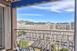 a balcony with a bench and a view of a city at Appart Lumineux I Prox Vélodrome in Marseille