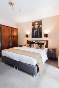 a large bedroom with a large bed with a poster on the wall at Turnhout City Hotel in Turnhout