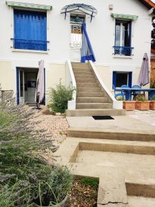un escalier en face d'une maison blanche dans l'établissement Dans maison individuelle : Appartement en rez-de jardin avec entrée indépendante, à Corbeil-Essonnes