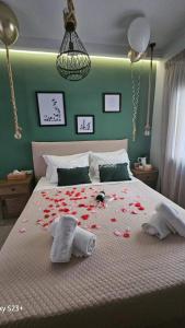 a bedroom with a bed covered in red rose petals at Damona 2BR Luxury Home with garden - κοντά στο κέντρο in Heraklio Town