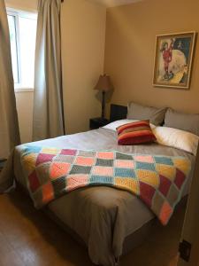 a bed with a colorful quilt on it in a bedroom at Les Chalets au Bord de la Mer in Les Escoumins