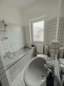 y baño con lavabo, bañera y aseo. en Geräumige 3-Schlafzimmer-Wohnung in Koblenz nahe Uni en Coblenza