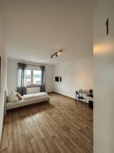 Habitación blanca con cama y escritorio. en Geräumige 3-Schlafzimmer-Wohnung in Koblenz nahe Uni en Coblenza