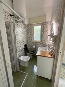 a bathroom with a sink and a toilet and a sink at Villa Paola by the sea in Cozze