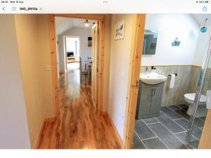 a bathroom with a wooden floor and a sink at Reka Vik in Stromness