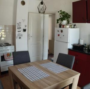 cocina con mesa de madera y nevera blanca en Apartman "Milka" Bajina Bašta en Bajina Bašta