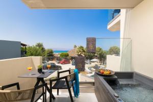 een balkon met een tafel en stoelen en uitzicht op een straat bij Elia Agia Marina Resort in Agia Marina Nea Kydonias