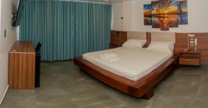 1 dormitorio con 1 cama y cortina verde en Hotel Rupa Rupa en Tingo María