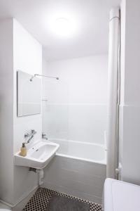 a white bathroom with a sink and a shower at ClickTheFlat Norblin Factory Apart Rooms in Warsaw