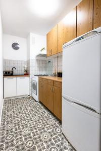 a kitchen with a white refrigerator and a tile floor at ClickTheFlat Norblin Factory Apart Rooms in Warsaw
