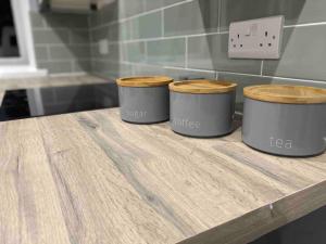 3 recipientes en una mesa de madera en una cocina en A modern and homely apartment en Crieff