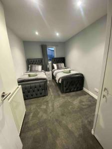 a room with two beds and a window at A modern and homely apartment in Crieff