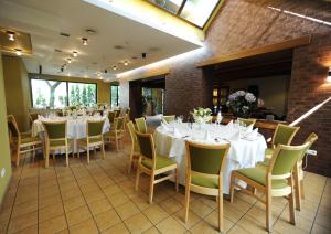 a dining room with white tables and chairs at Hotel Senas Namas in Alytus