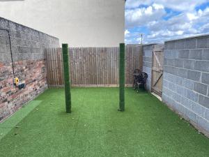 a patio with green grass and a wooden fence at Humber Maisonette Airy, Modern & Chic! in Goole