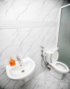 a white bathroom with a toilet and a sink at Snow View Rau Apartments in Moshi +28 photos