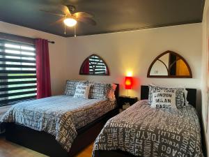 sypialnia z 2 łóżkami i wentylatorem sufitowym w obiekcie Auberge La Table d'Hôte w mieście West Brome