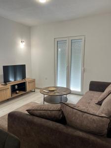 uma sala de estar com um sofá e uma mesa em Knežević apartman 