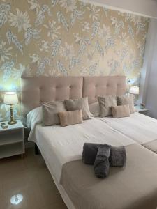 a bedroom with a large white bed with a floral wallpaper at SeaMed in Málaga +22 photos