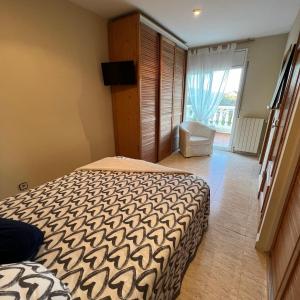 a bedroom with a bed and a television and a window at Habitación Atalaya in Olivella +15 photos