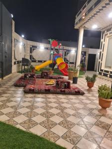 a playground with a slide on a patio at فيلا ميسرة الهدا in Al Hada
