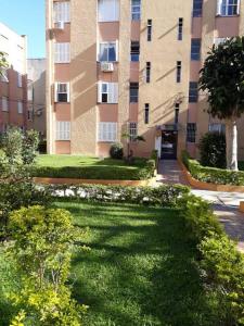 a large building with a lawn in front of it at Apartamento 2 quartos in Pelotas