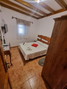 a bedroom with a bed and a wooden door at CASA PABLITO in San Bartolomé