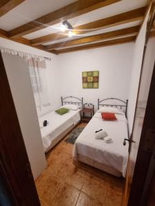 a room with two beds in a room with a hallway at CASA PABLITO in San Bartolomé de Tirajana