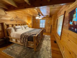 - une chambre avec un lit dans une cabane en rondins dans l'établissement Elegant & Cozy Cabin Near Pigeon Forge, à Sevierville
