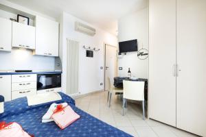 uma cozinha e uma sala de estar com uma cama e uma mesa em We Home - PALESTRINA17 - Riccione sul mare em Riccione